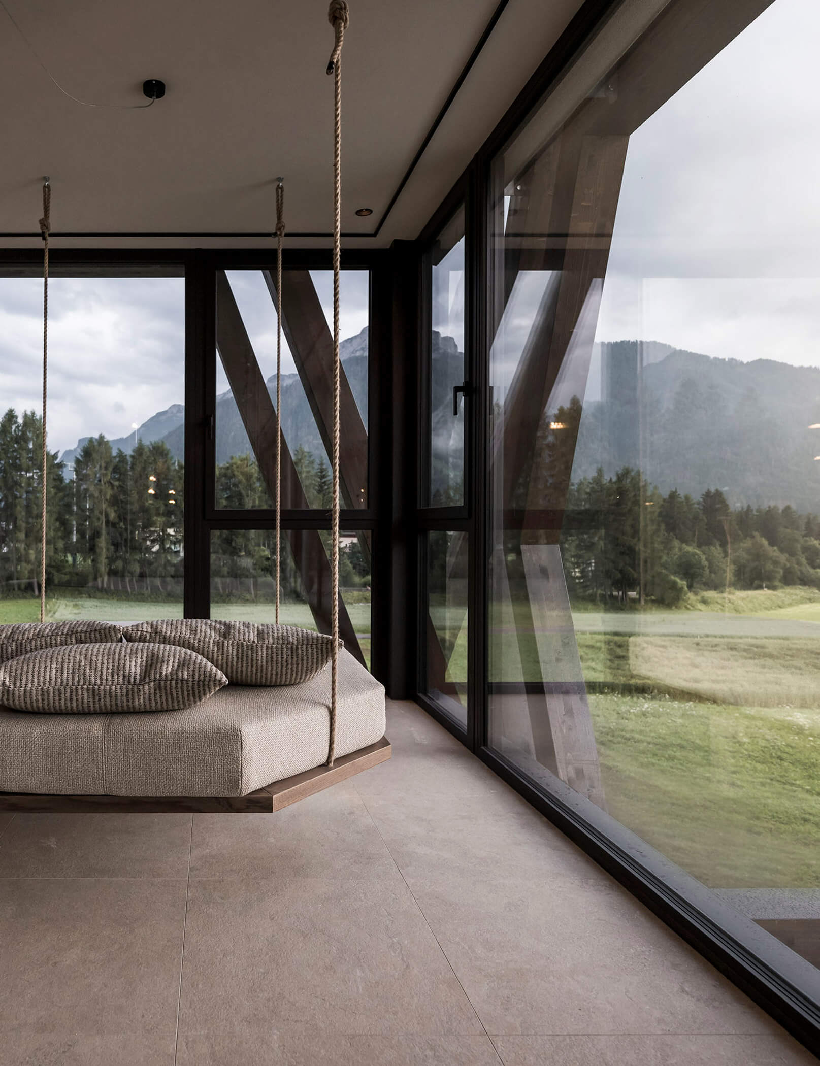 Sala relax con lettino sospeso e vista su prati e alberi - Hotel Patris