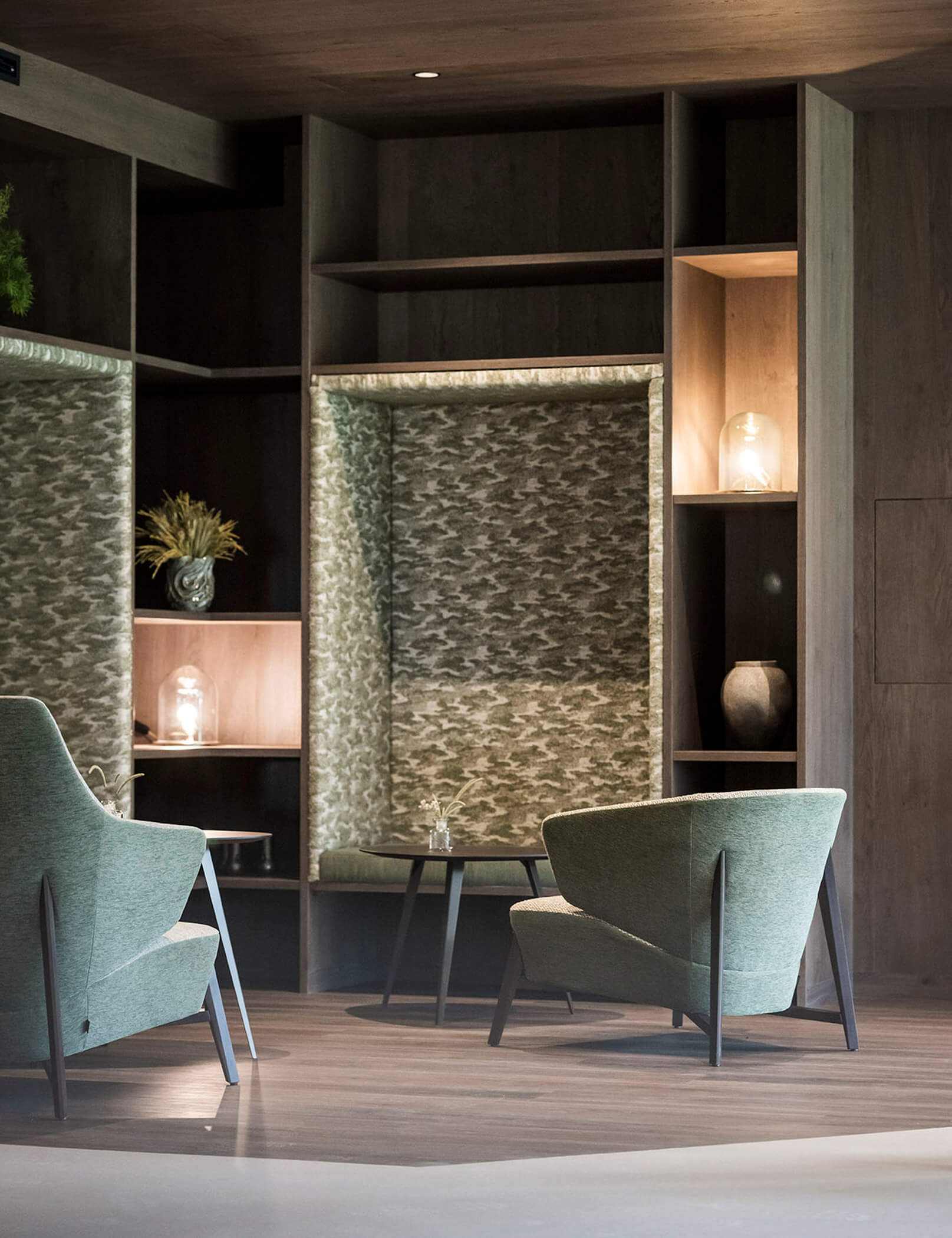 Poltrone verdi, tavolo marrone e pavimento in legno - Hotel Patris