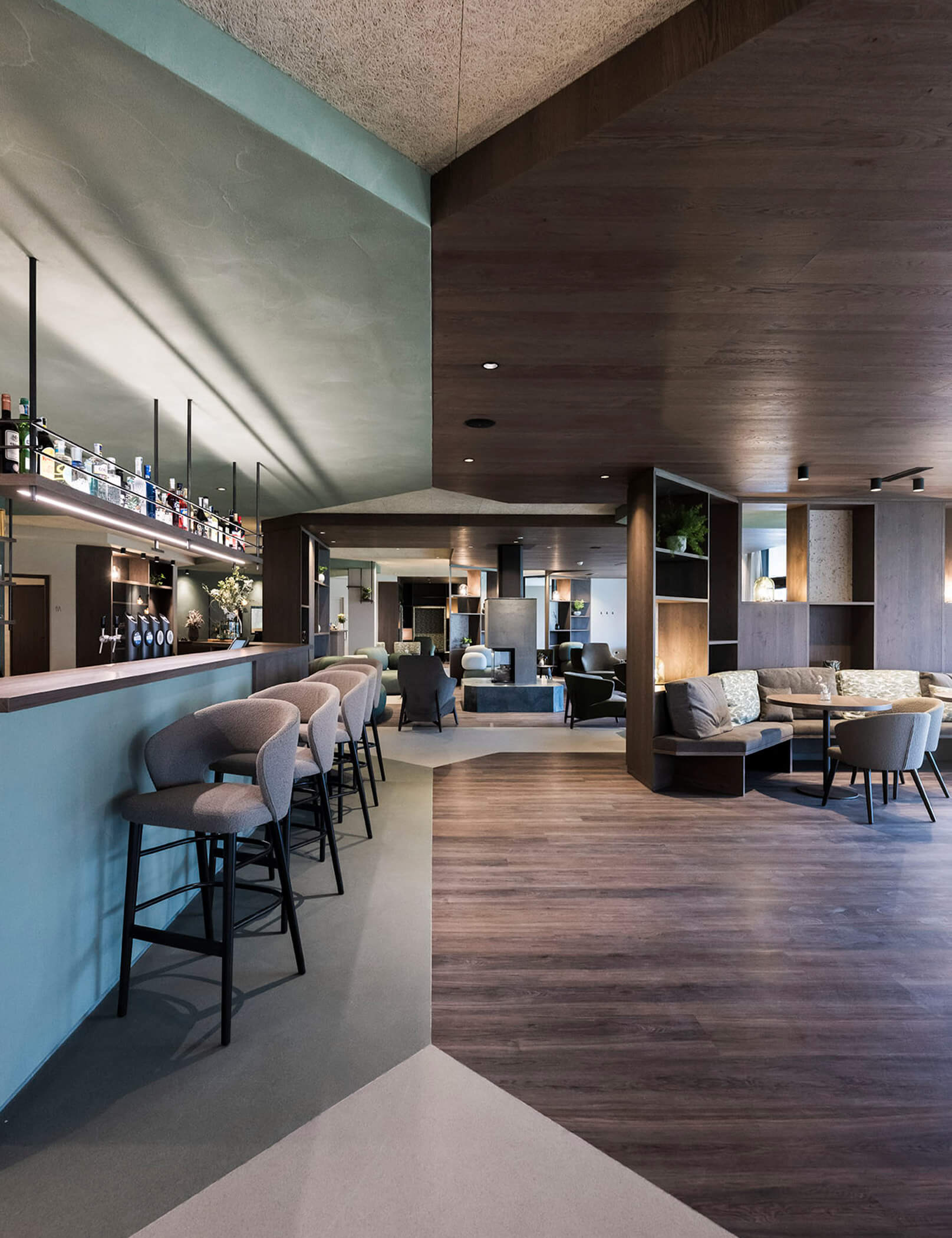 A sinistra il bar con sgabelli, a destra tavoli con sedie e panche - Hotel Patris