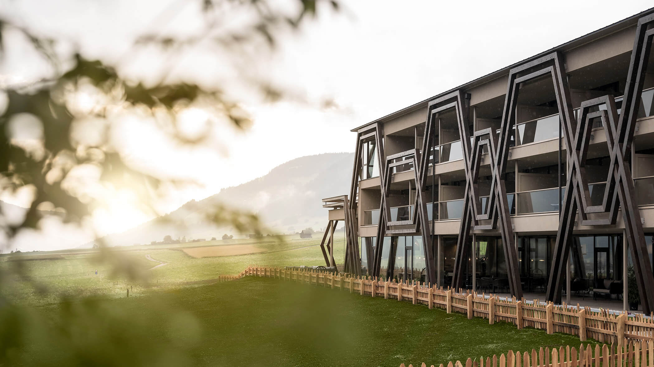 Das Hotel Patris von außen mit Holzzaun und grünen Wiesen