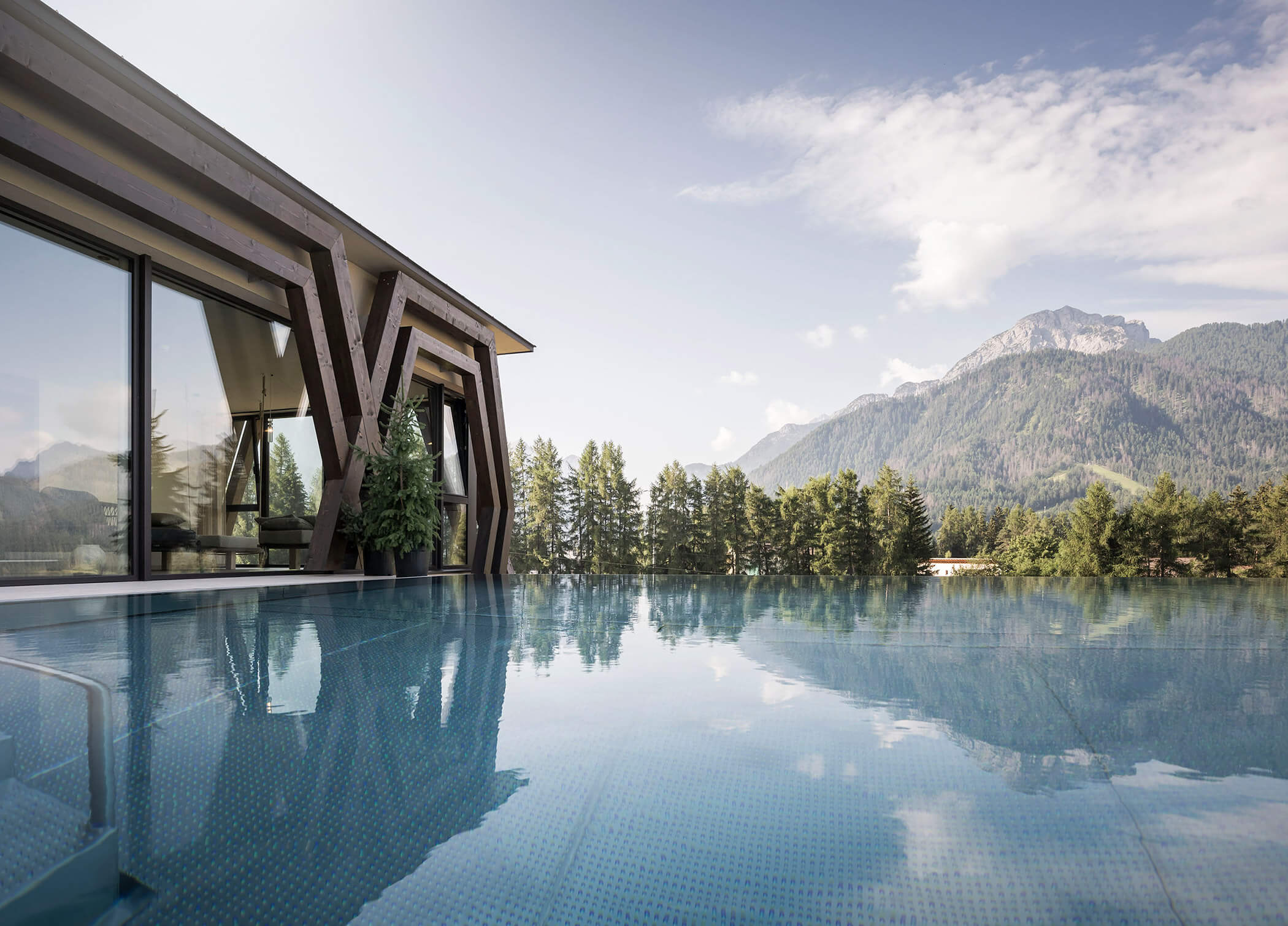 Außenpool mit Blick auf Bäume und Berge - Hotel Patris