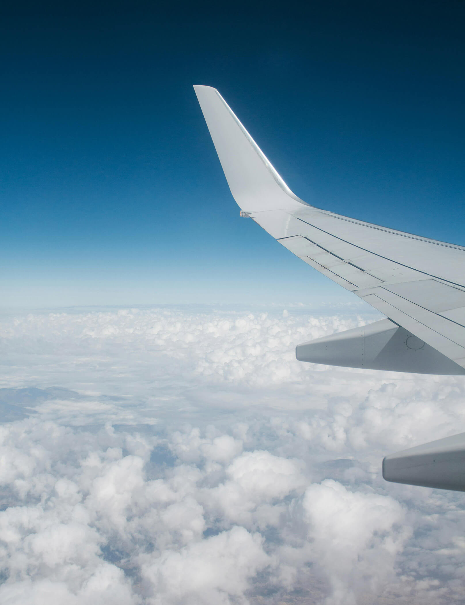 Ala di aereo con nuvole e cielo blu sullo sfondo - Hotel Patris