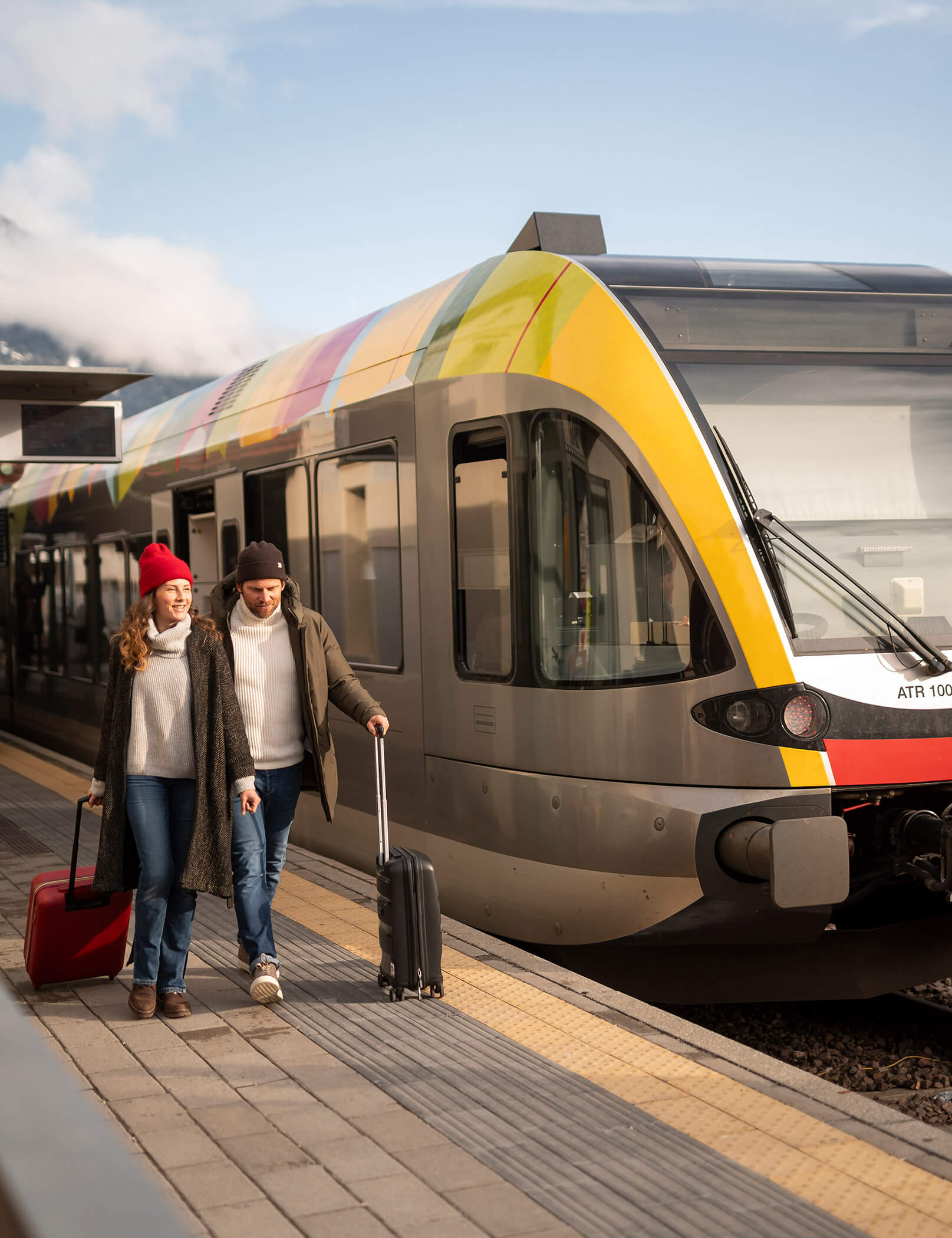 Una coppia scende dal treno con le valigie - Hotel Patris