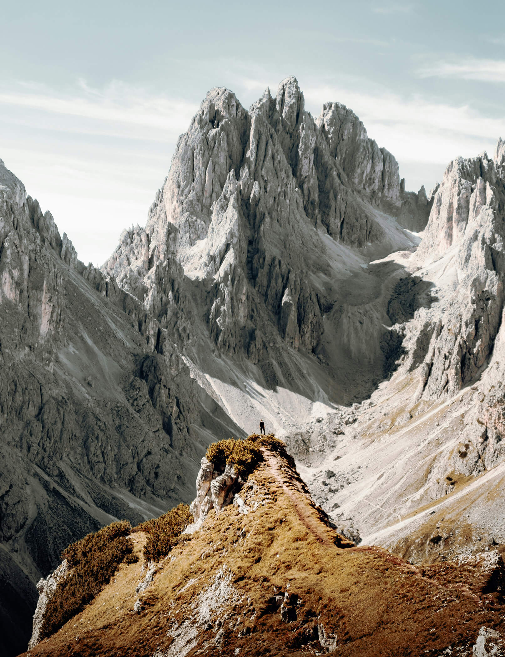 Eine Person steht inmitten einer atemberaubenden Bergkulisse - Hotel Patris