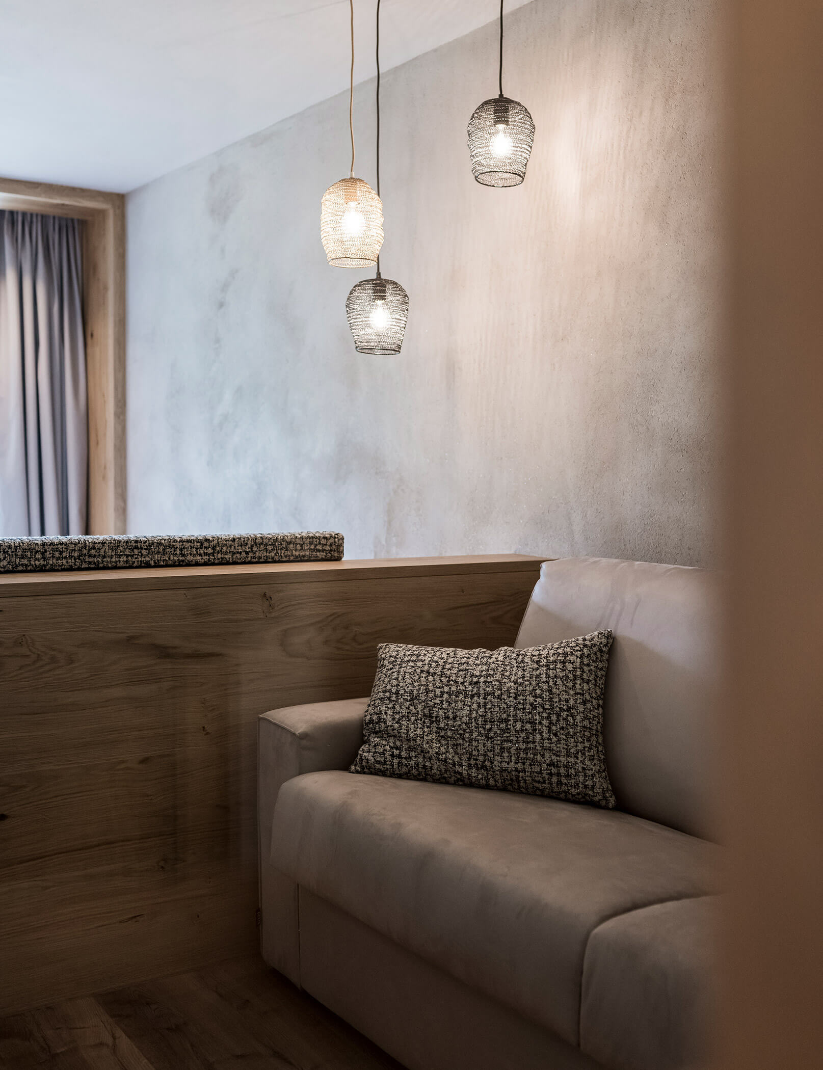 Divano grigio chiaro con cuscino a quadri - Hotel Patris